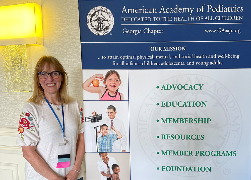 A member of the GAAAP in front of a GAAAP banner.